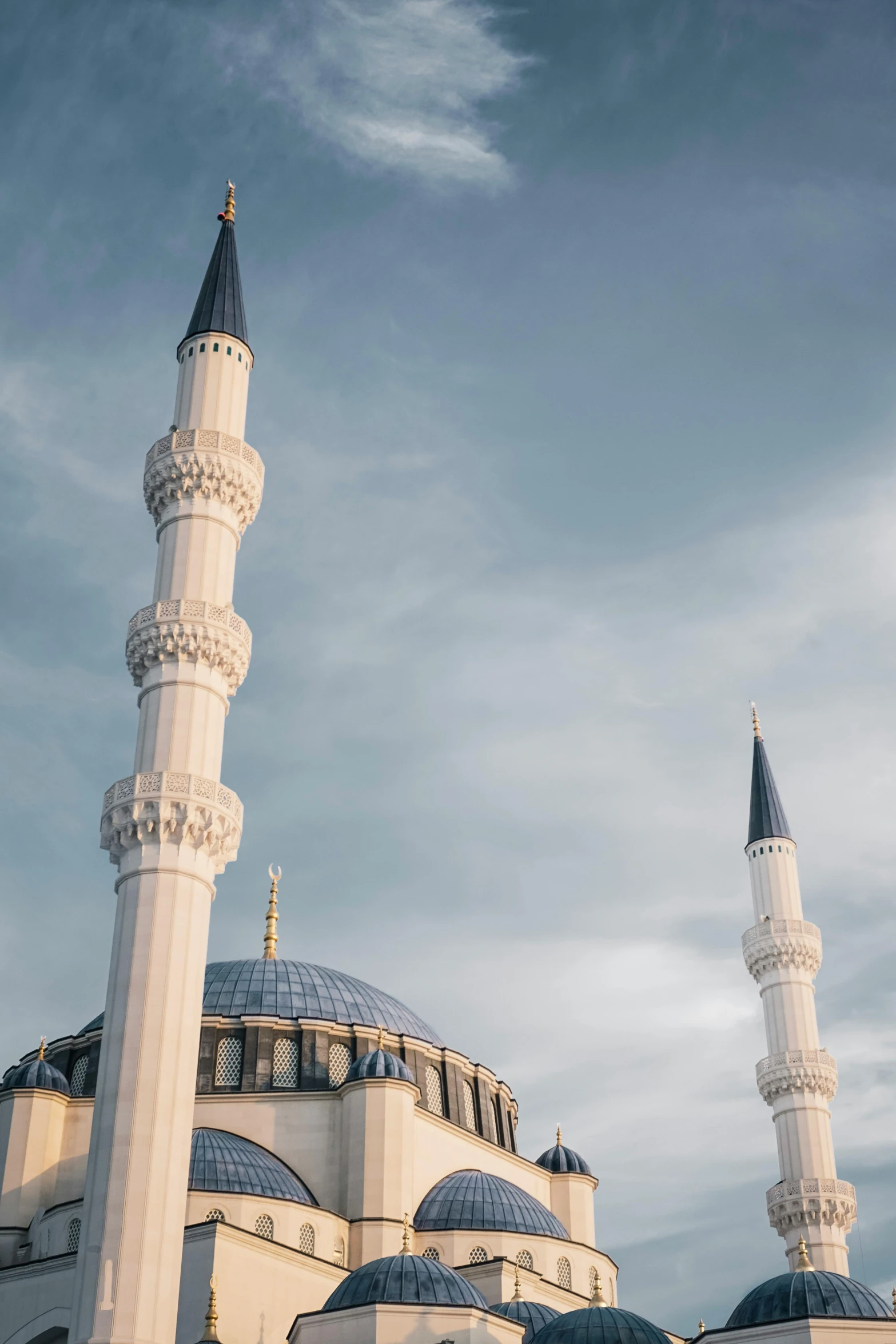 a large white mosque with blue domes under a cloudy sky, a colorized photo, unsplash contest winner, two organic looking towers, square, ripple, paisley