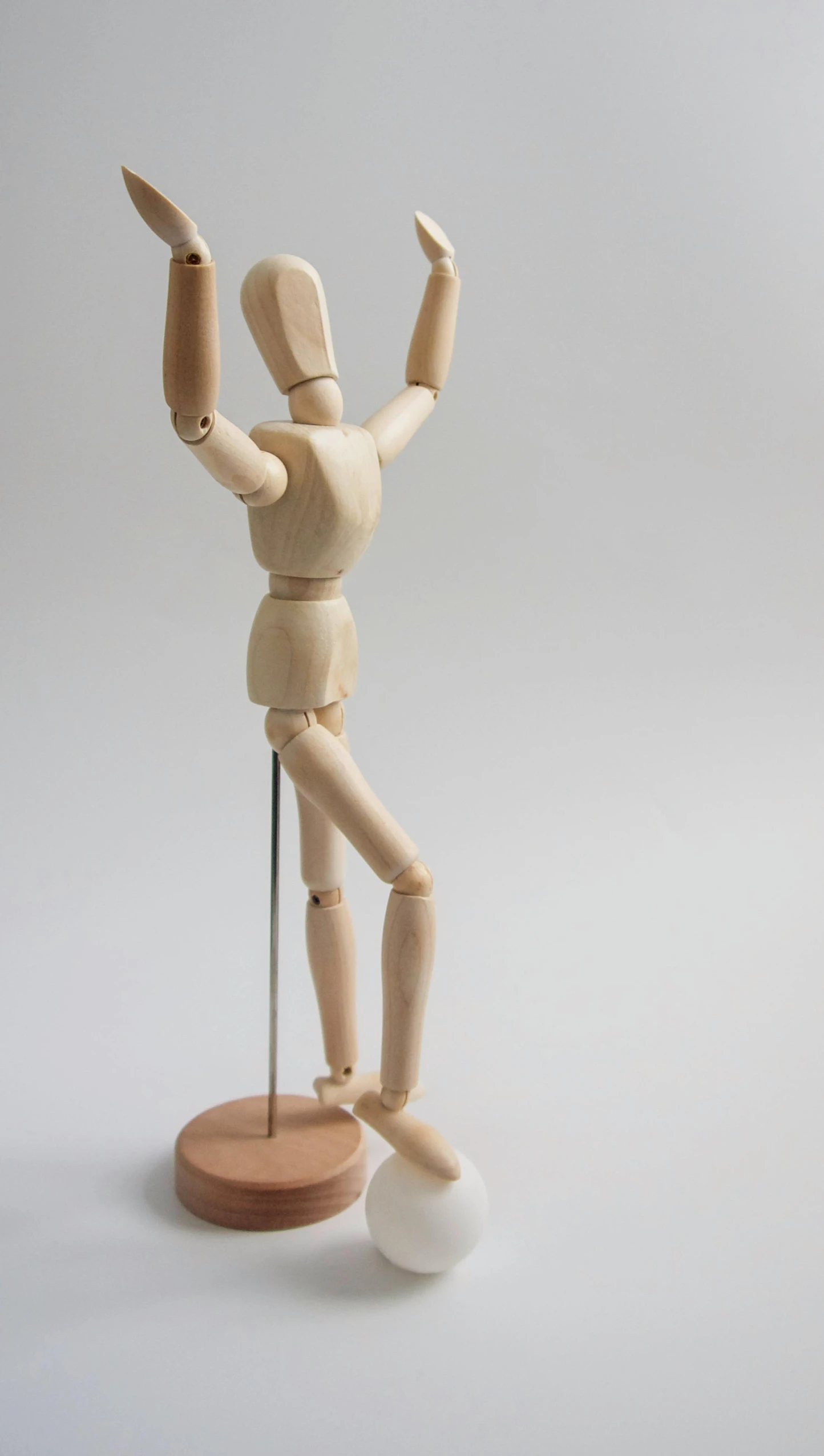a wooden mannequin standing on a wooden base, by David Simpson, unsplash, articulated joints, with arms up, pose 4 of 1 6, acrobat