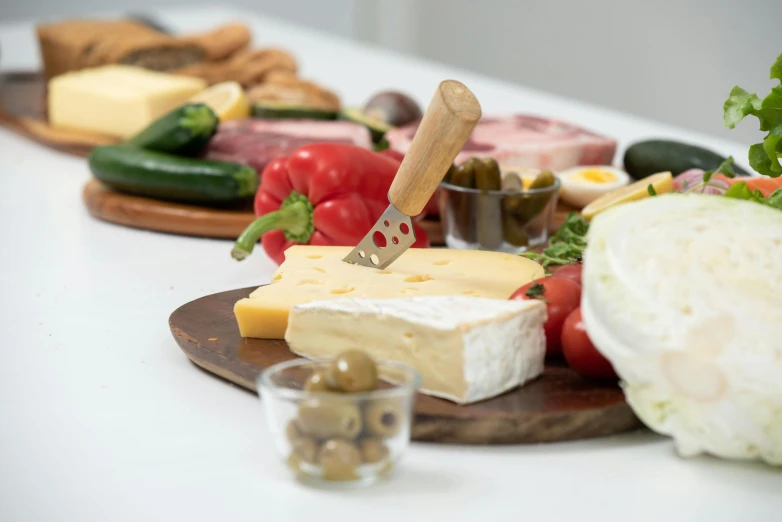 a table topped with lots of different types of food, detailed product image, close up shot from the side, cheese revolution, white