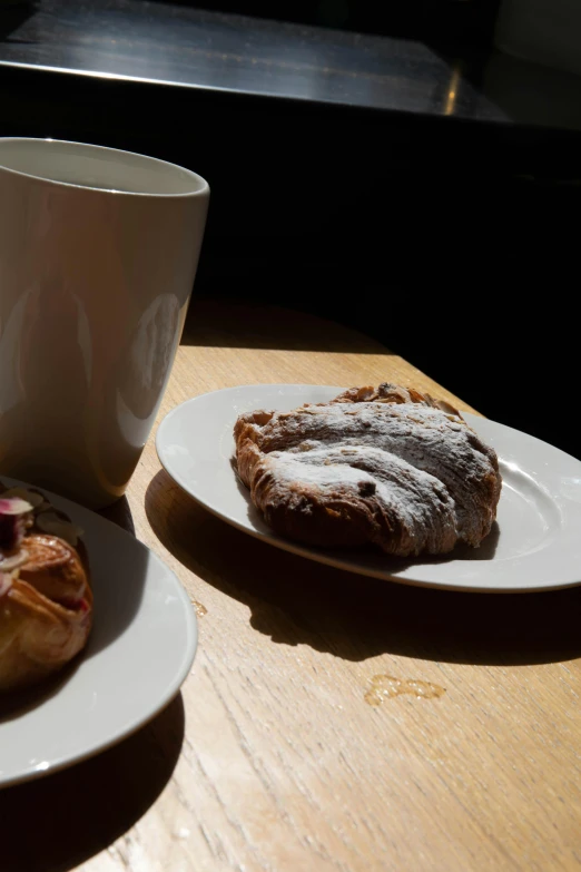 a table with two plates of food and a cup of coffee, inspired by Gillis Rombouts, unsplash, photorealism, pastries, 2 5 6 x 2 5 6 pixels, close - up photograph, san francisco