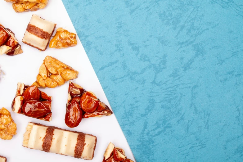 a table topped with lots of different types of food, an album cover, trending on pexels, with a blue background, eating mars bar candy, background image, full view blank background