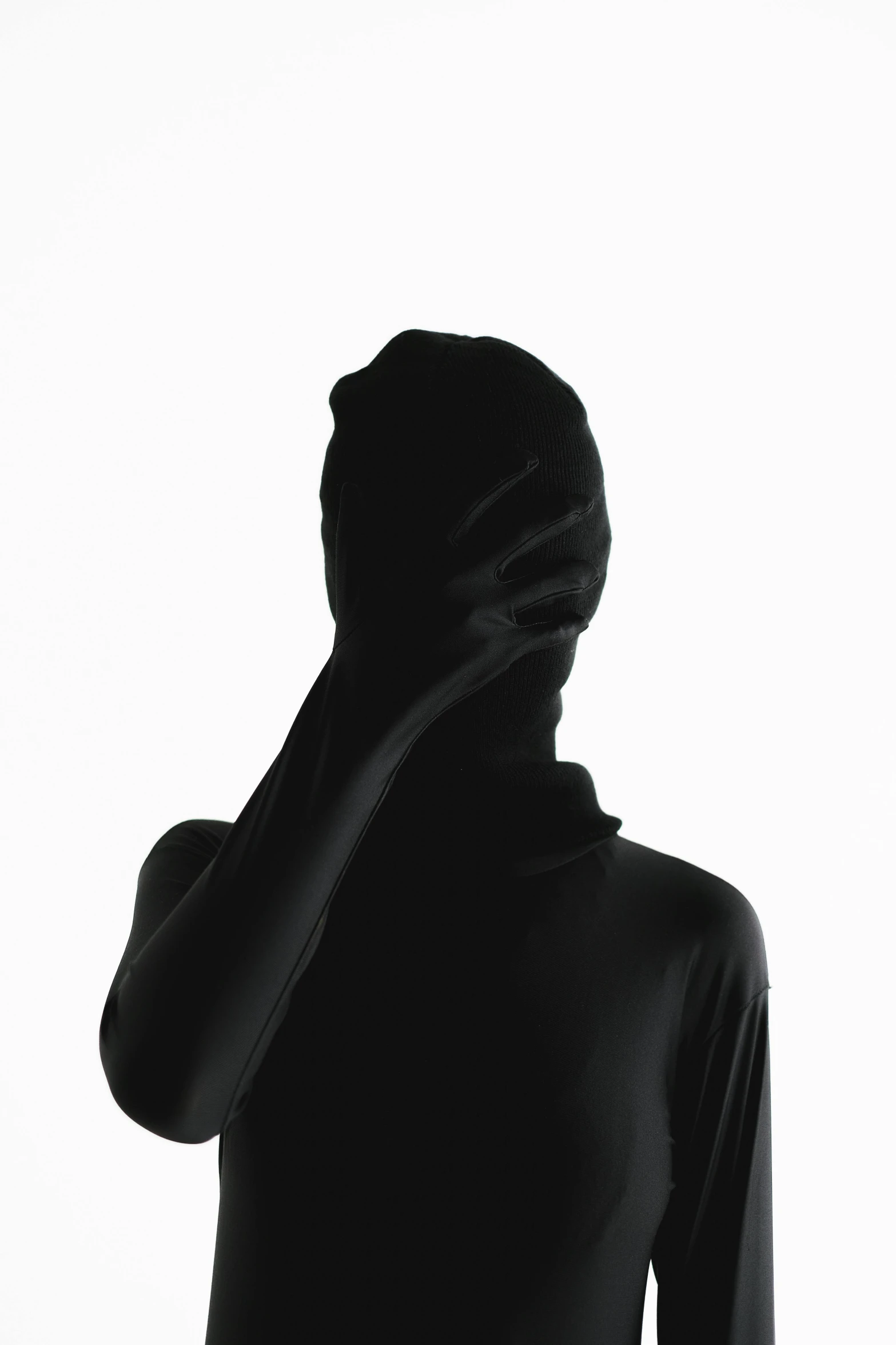 a silhouette of a woman covering her face with a hood, an album cover, unsplash, zentai suit, isolated, mundane, instagram photo