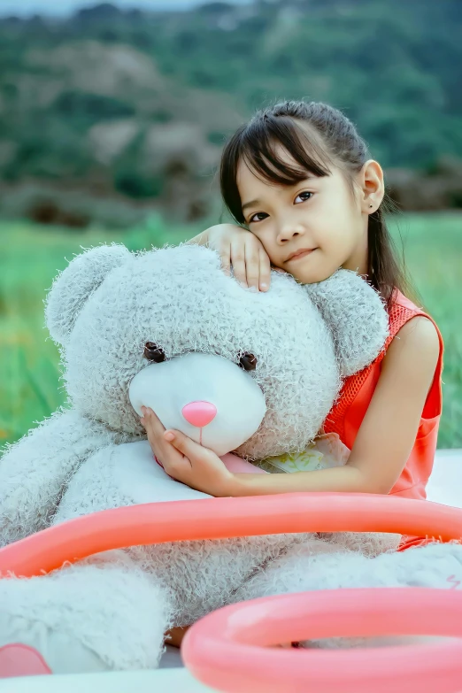 a little girl sitting next to a giant teddy bear, a picture, pexels contest winner, mai anh tran, closeup portrait, grey, natural beauty