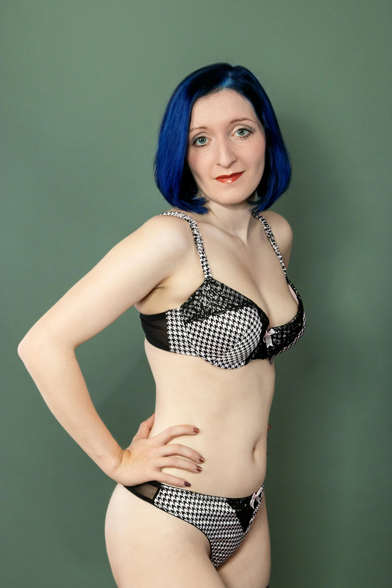 a woman with blue hair posing for a picture, a colorized photo, inspired by Jessie Alexandra Dick, featured on reddit, lingerie, polkadots, physical : tinyest midriff ever, studio portrait