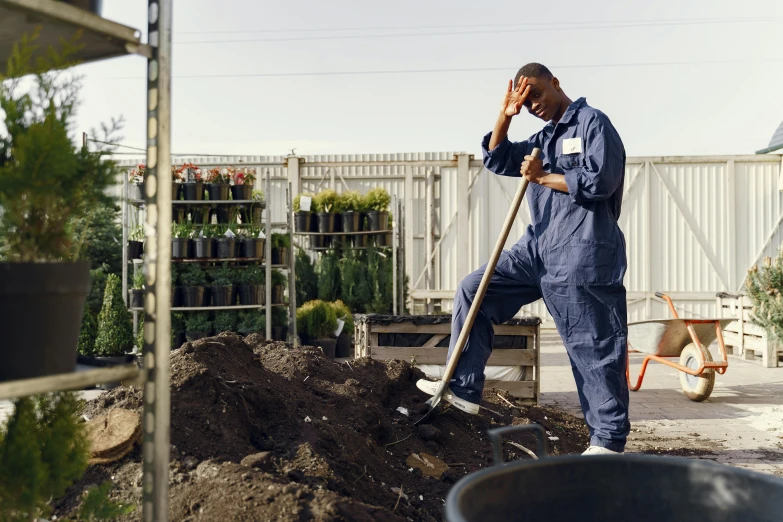 a man that is standing in the dirt with a shovel, unsplash, renaissance, in bloom greenhouse, wearing human air force jumpsuit, sprawled out, work clothes