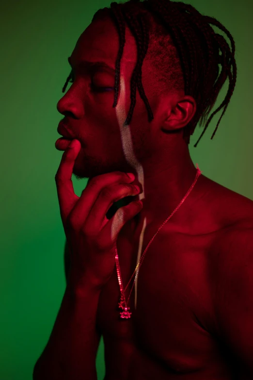 a man with dreadlocks smoking a cigarette, an album cover, trending on pexels, red and green lighting, playboi carti portrait, photo of a hand jewellery model, red flesh strings