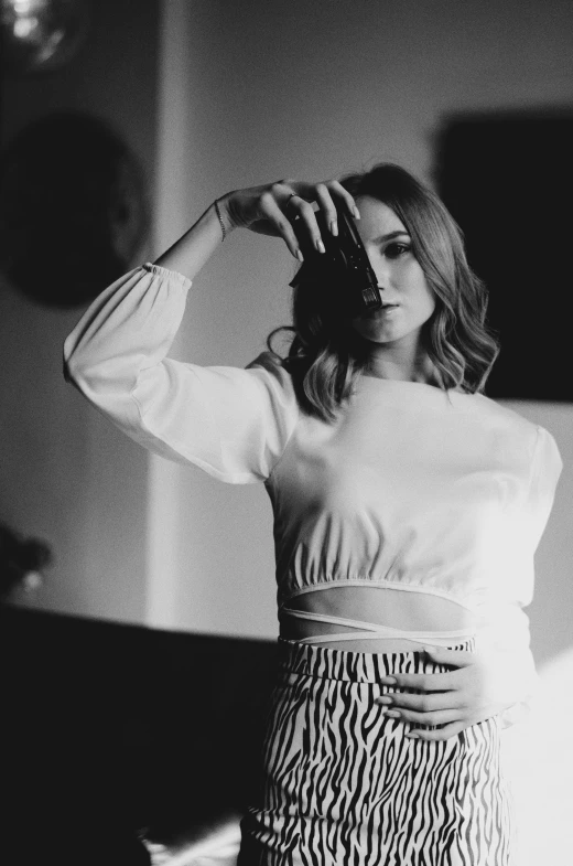 a black and white photo of a woman in a dress, inspired by Claire Dalby, pexels contest winner, camilla luddington, wearing a cropped top, wearing beautiful clothes, shooting pose