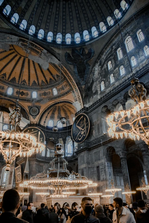 a group of people standing inside of a building, by irakli nadar, trending on unsplash, baroque, with great domes and arches, turkey, church chandelier, panoramic shot