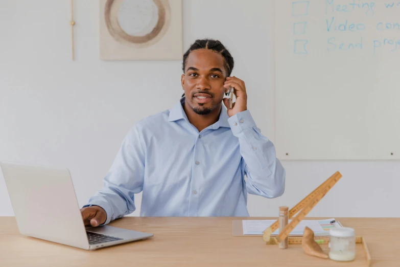 a man sitting at a desk talking on a cell phone, by Anthony S Waters, pexels contest winner, wearing business casual dress, avatar image, jemal shabazz, confident stance