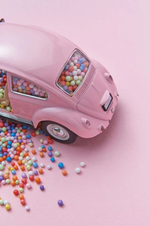 a pink toy car sitting on top of a pile of sprinkles, inspired by Chris LaBrooy, pexels contest winner, photorealism, beetle, jellybeans, avatar image, inside of a car