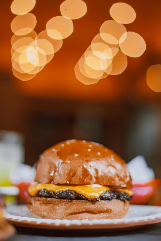 a hamburger sitting on top of a white plate, bright lights, profile image, melted cheddar, heavy bokeh