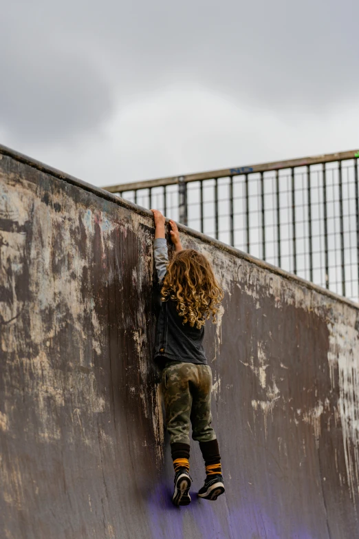 a man riding a skateboard up the side of a ramp, inspired by Banksy, unsplash, graffiti, migrant mother, panoramic view of girl, rusted metal, military photography