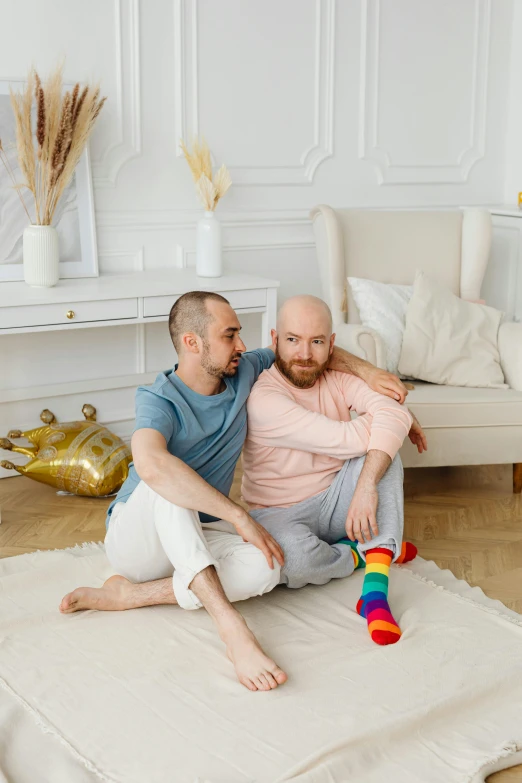 a man and a woman sitting on a rug in a living room, by Julia Pishtar, shutterstock, renaissance, two men hugging, gay pride, portrait of bald, фото девушка курит