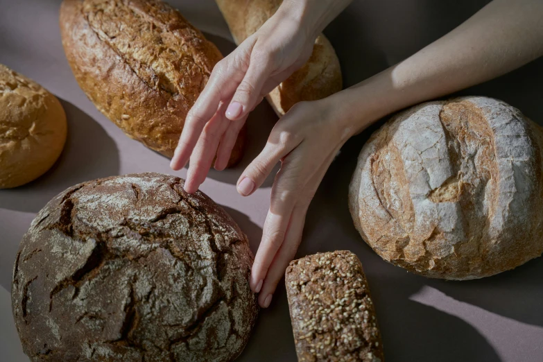 a person reaching for a loaf of bread, a portrait, by Helen Stevenson, trending on pexels, mineral grains, various posed, high angle close up shot, - photorealistic