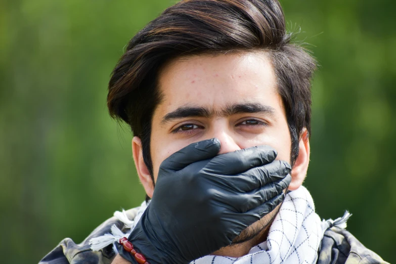 a man with a scarf and gloves covering his mouth, by Nina Hamnett, shutterstock, square masculine jaw, shabab alizadeh, outdoor photo, acid leaking from mouth