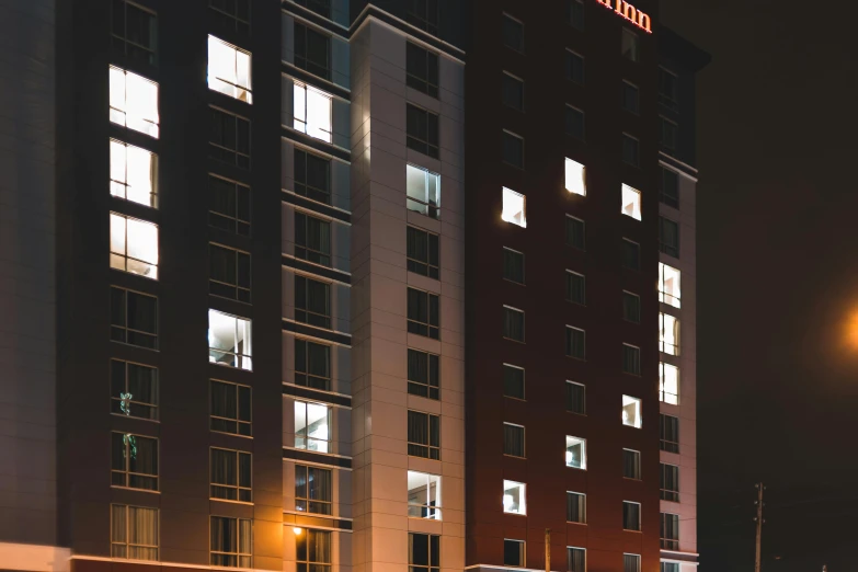 a very tall building with a lot of windows, by Washington Allston, unsplash, orange and red lighting, hotel, brown, archviz