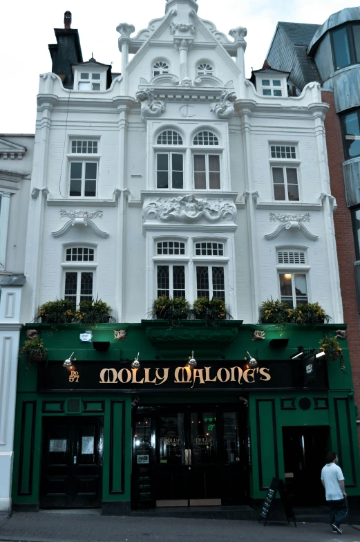 a large white building sitting on the side of a street, inspired by Aloysius O'Kelly, art nouveau, pub sign, molly millions, 1 9 th century london, galleon