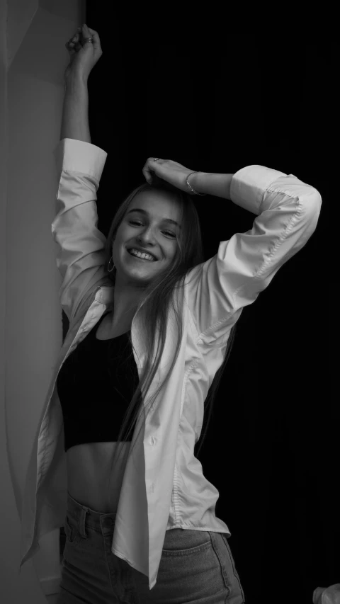 a black and white photo of a woman wearing a tie, a black and white photo, by Emma Andijewska, pexels contest winner, photorealism, smiling and dancing, young blonde woman, white sleeves, lights