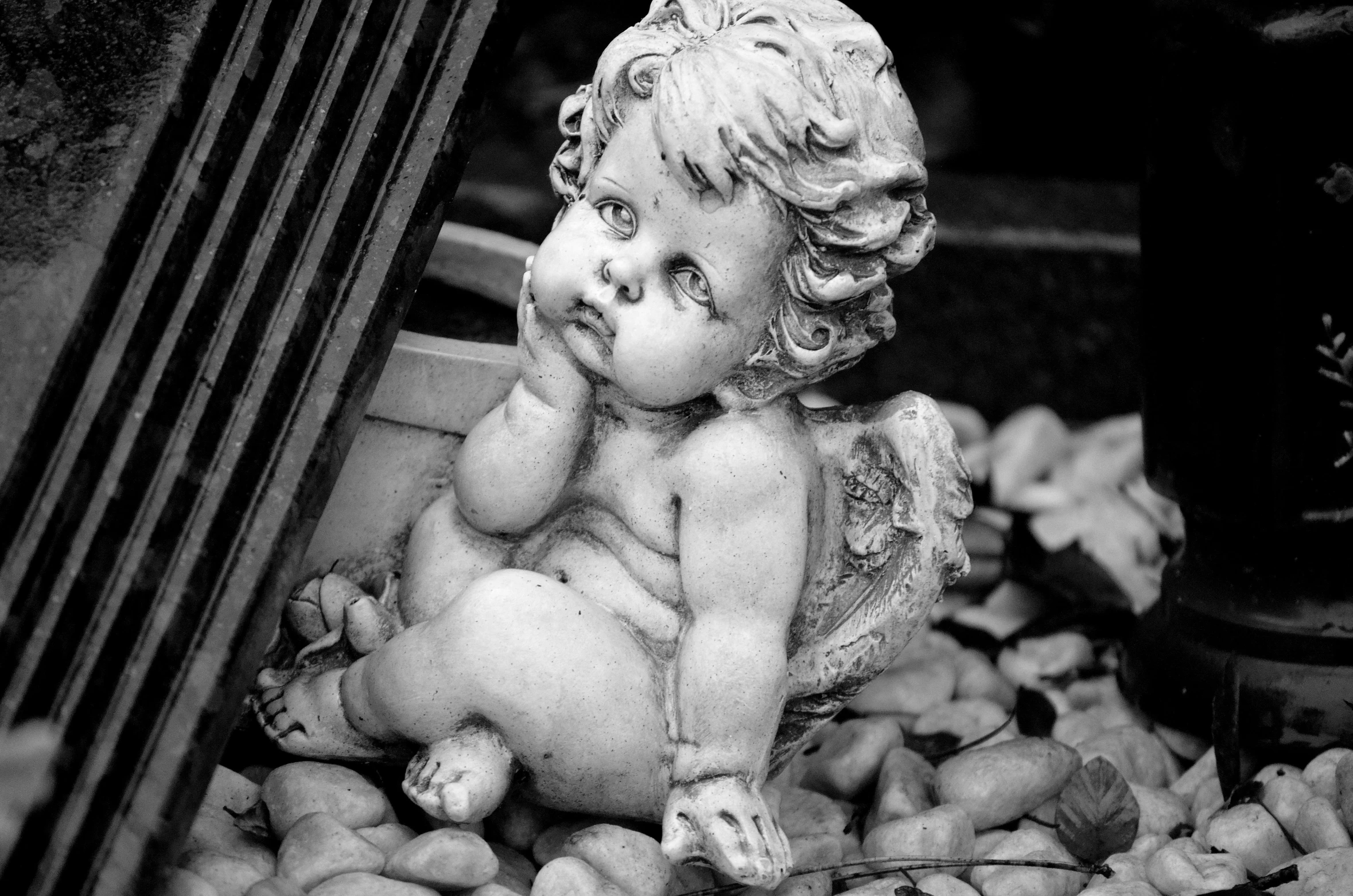 a statue of an angel sitting on a pile of apples, by Marie Angel, pexels, concrete art, black and white color only, cherub, rubble!!, pouty face