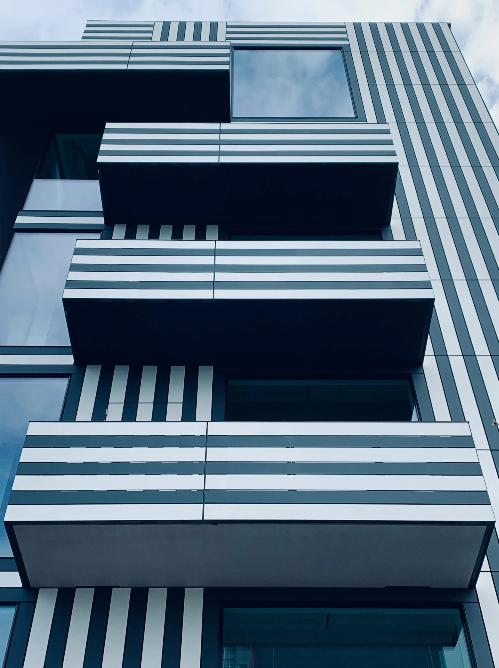 a tall building with many windows and balconies, an album cover, inspired by Donald Judd, unsplash, black stripes, high angle close up shot, awnings, award-winning render