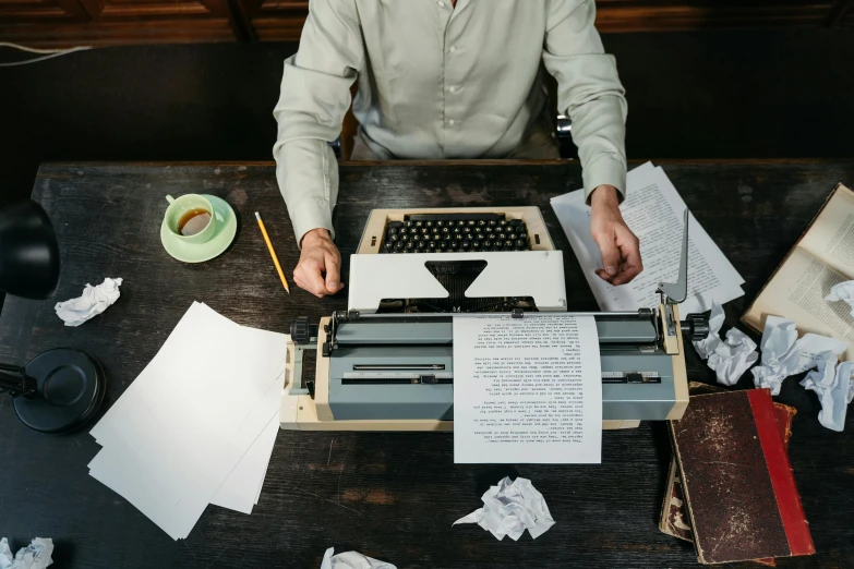 a man is typing on an old typewriter, pexels contest winner, character sheets on table, as well as scratches, creating a soft, promo image