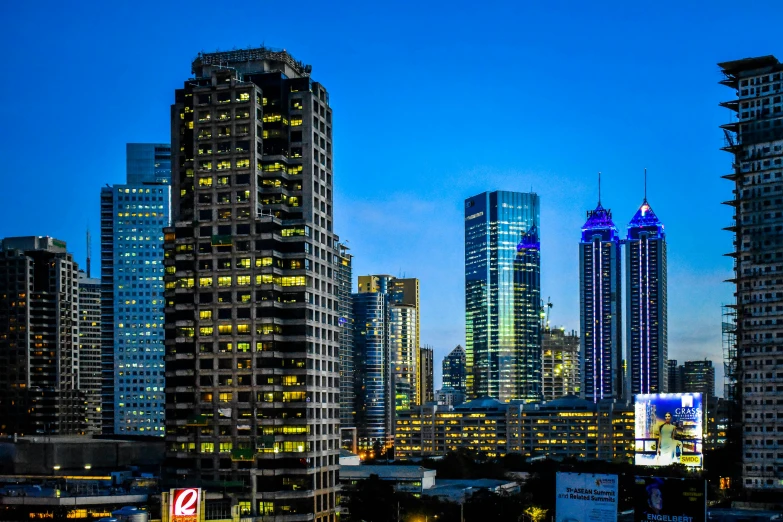 the city skyline is lit up at night, by Erik Pevernagie, pexels contest winner, hyperrealism, three towers, early morning lighting, high detailed photo, neon blue and yellow lights