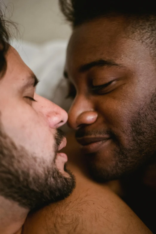 a couple of men laying in bed next to each other, a photo, trending on pexels, kiss mouth to mouth, diverse colors, close up half body shot, bowater charlie and brom gerald