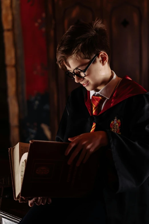 a young man dressed as harry potter reading a book, a portrait, trending on pexels, hogwarts legacy, silk robes, promo image, teenage boy