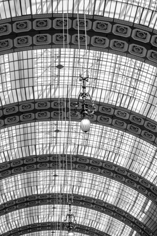 a black and white photo of a train station, inspired by Henri Cartier-Bresson, flickr, art nouveau, big chandelier, ffffound, square lines, glass dome