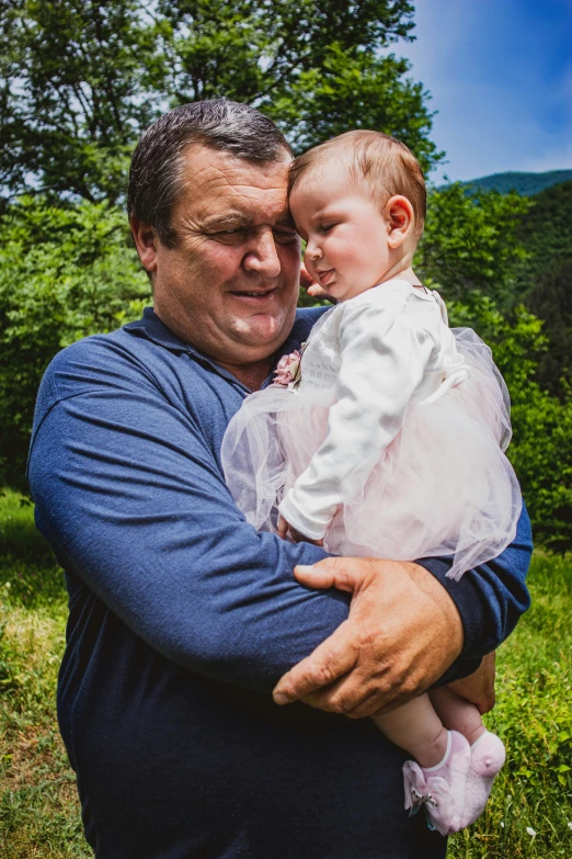 a man holding a baby in his arms, a picture, by Alexander Fedosav, pixabay contest winner, viktor orban in a forest, color photograph portrait 4k, photo of a 50-year-old white man, 15081959 21121991 01012000 4k