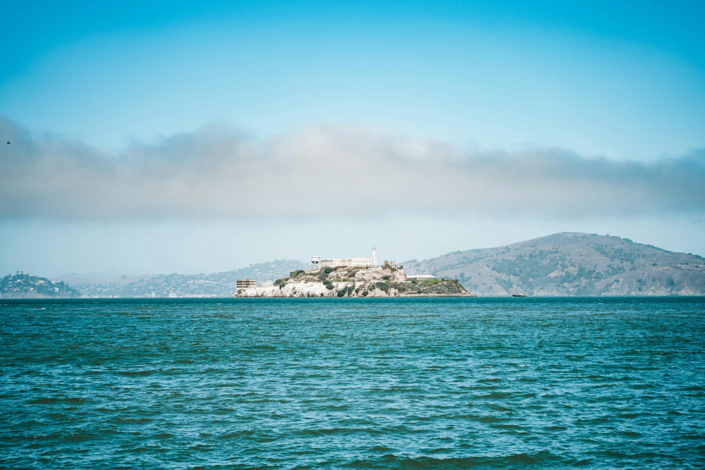 a large body of water with a small island in the background, unsplash, renaissance, photograph of san francisco, wes anderson background, promo image, multiple stories