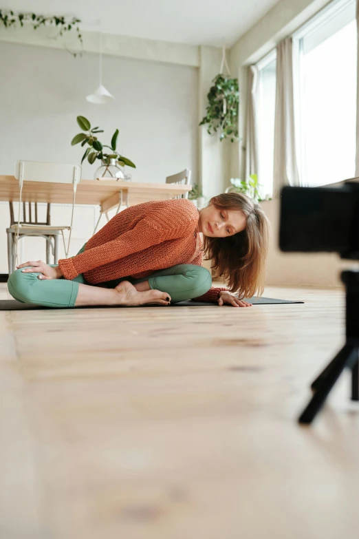 a woman laying on the floor in front of a camera, yoga, sitting on top a table, video compression, easy to use