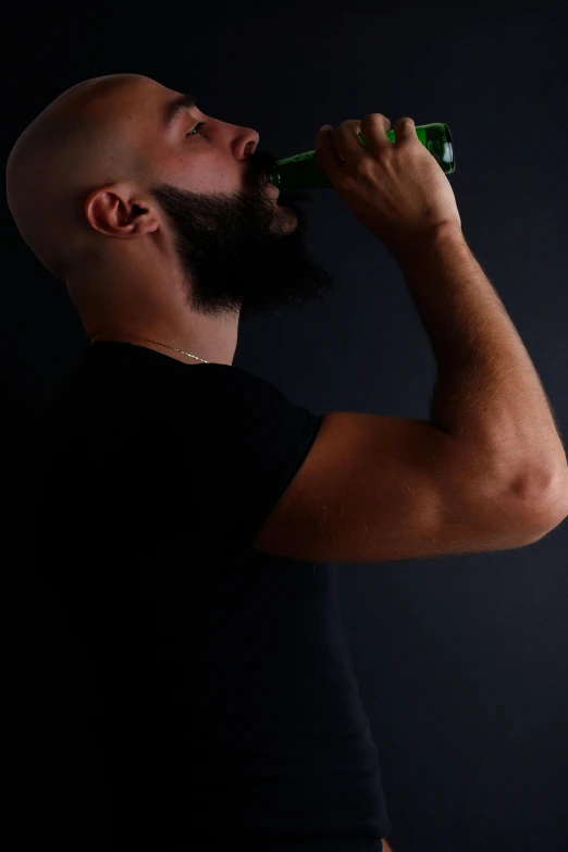 a man with a beard drinking from a bottle, inspired by Jack Smith, pexels contest winner, renaissance, muscular bald man, profile image, club photography, with a beard and a black shirt