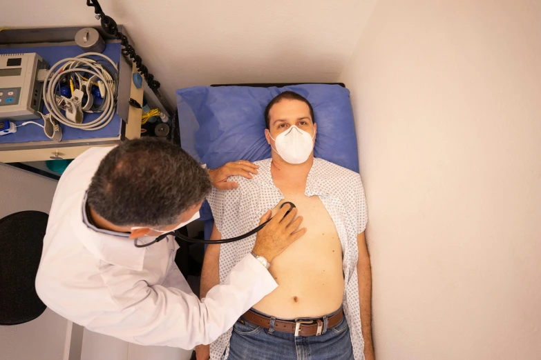 a doctor examining a patient's chest with a stethoscope, by Daniel Lieske, pexels contest winner, hyperrealism, masked person in corner, são paulo, full body 8k, 45 years old men