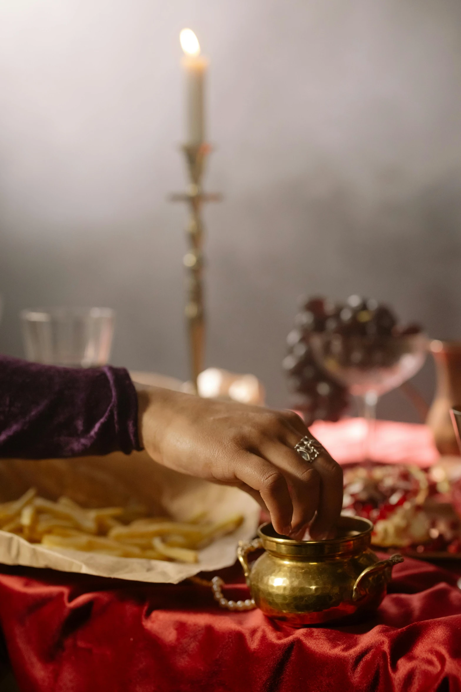 a person sitting at a table with a plate of food, inspired by Osman Hamdi Bey, trending on pexels, renaissance, moody details, sacrificial altar, still frame from a movie, gold