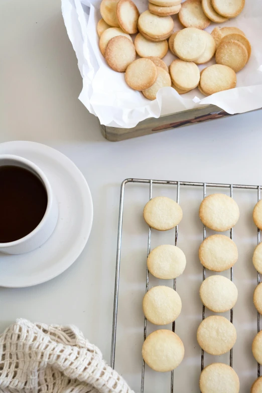 a tray of cookies sitting on top of a table next to a cup of coffee, by Nicolette Macnamara, square, thumbnail, chile, white