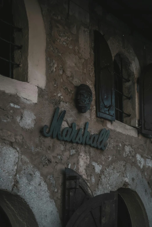 a sign that is on the side of a building, inspired by Marshall Arisman, unsplash, gothic mansion room, marbella landscape, marshal mathers, ( ( theatrical ) )