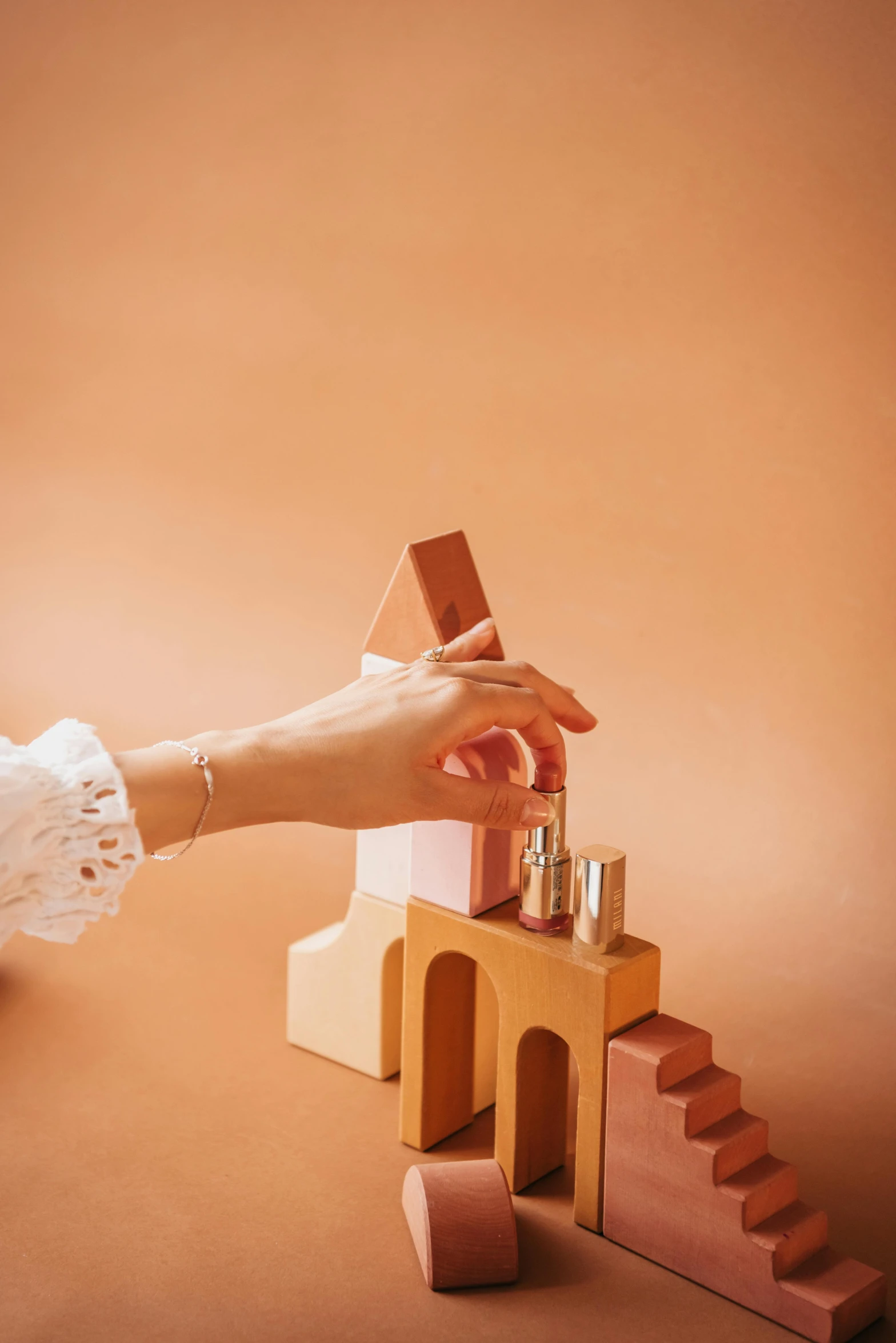 a person building a house out of wood blocks, inspired by Giorgio Morandi, trending on unsplash, photoshoot for skincare brand, ivory and copper, toy photo, pink arches