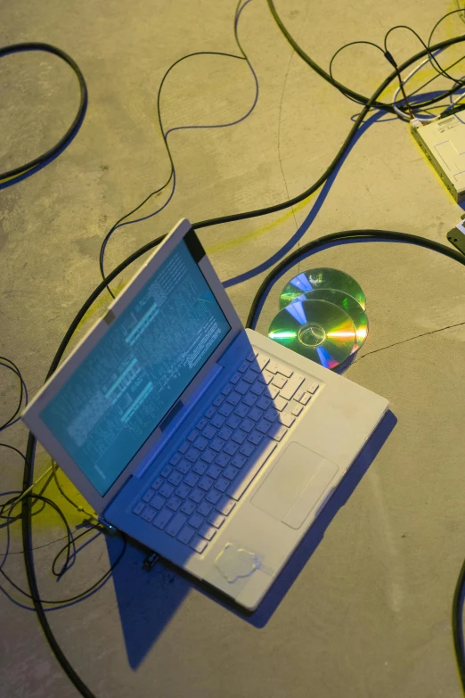 a laptop computer sitting on top of a table, an album cover, flickr, cables on floor, at a rave, computer science, ( ( photograph ) )