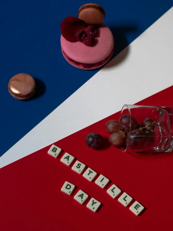 a glass of wine sitting on top of a red, white and blue table, a still life, by Daniël Mijtens, trending on unsplash, de stijl, detailed letters, made out of sweets, french kiss, medium shot taken from behind