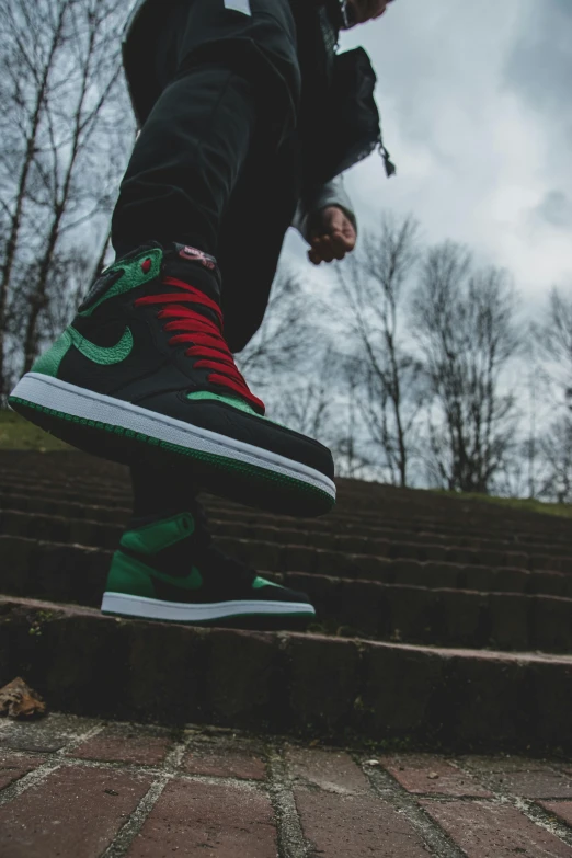 a man riding a skateboard down a flight of stairs, an album cover, inspired by Jordan Grimmer, trending on pexels, acid-green sneakers, red green black teal, profile pic, “air jordan 1