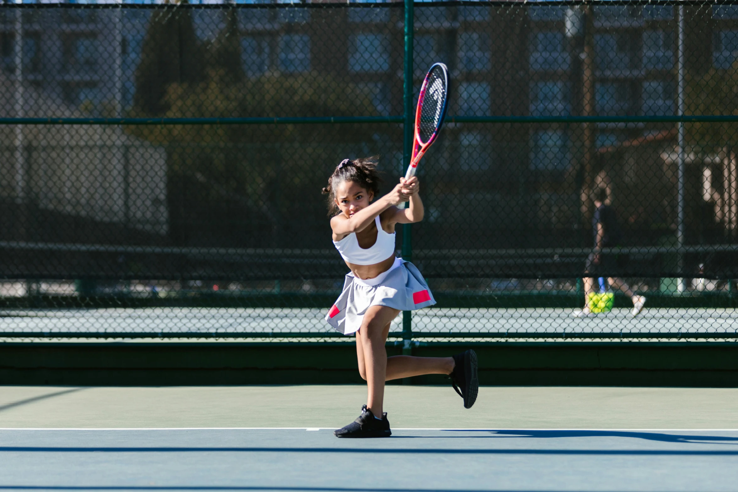 a young girl holding a tennis racquet on a tennis court, unsplash, mid action swing, jen atkin, panoramic view of girl, mai anh tran