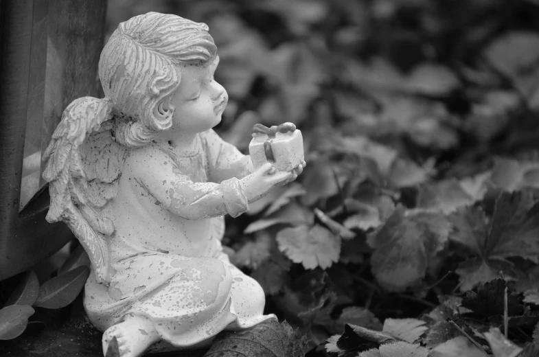 a black and white photo of a statue of an angel, pixabay contest winner, holding gift, cute and lovely, sitting in the garden, hand