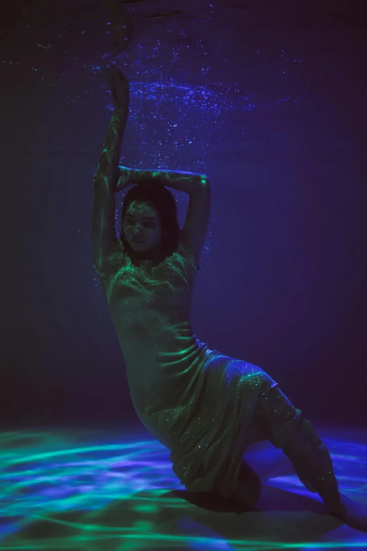 a woman laying on the ground under water, an album cover, inspired by Elsa Bleda, unsplash, green and purple studio lighting, full body image, holographic projection, wearing a dress made of water