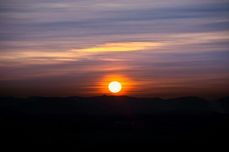 the sun is setting over a mountain range, by Ian Fairweather, pexels contest winner, romanticism, sun shaft, black mountains, zoomed out, horizon view