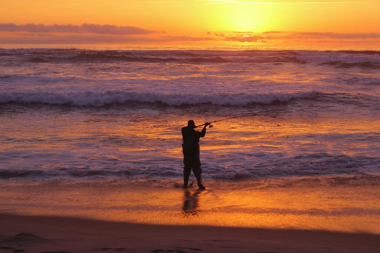 a man standing on top of a beach next to the ocean, fishing, profile image, orange dawn, new zeeland