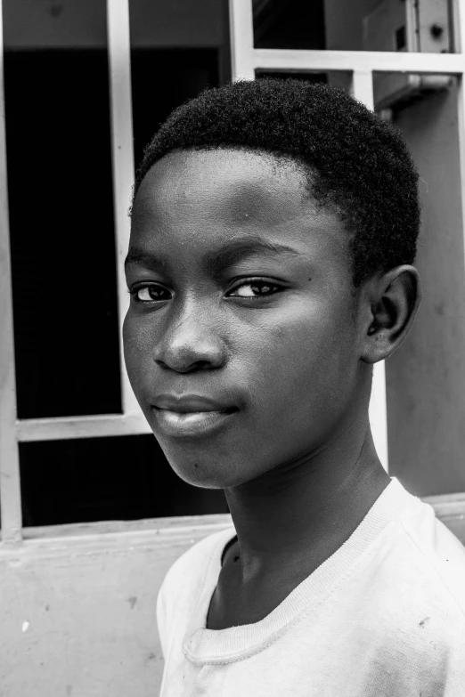 a young boy standing in front of a building, an album cover, inspired by Chinwe Chukwuogo-Roy, bw close - up profile face, a handsome, pupil, headshot profile picture