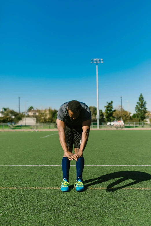 a man standing on top of a soccer field, recovering from pain, athletic crossfit build, profile image, disappointed