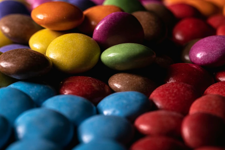 a pile of colorful candy sitting on top of a table, inspired by Damien Hirst, pexels contest winner, brown red blue, beans, deep colours, kek