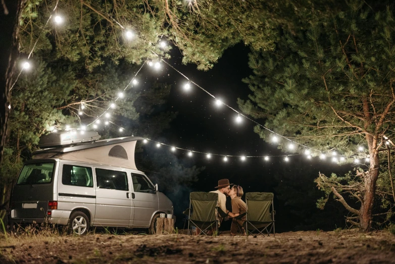 a camper van parked under a string of lights, renaissance, forest picnic, profile image, exterior shot